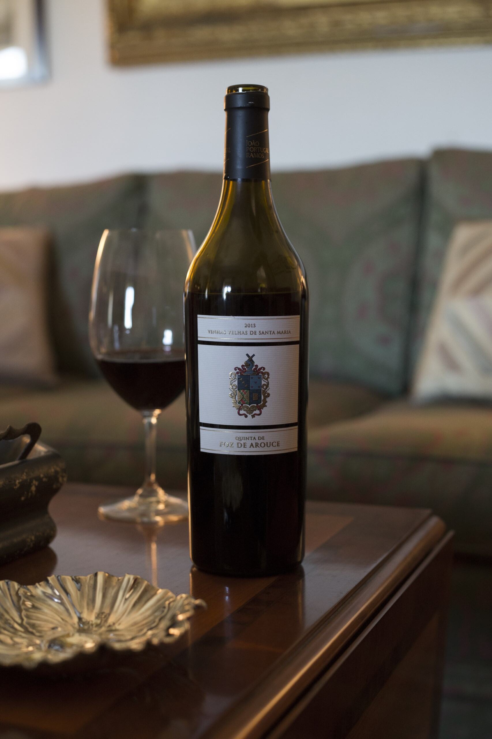 Quinta de Foz de Arouce Vinhas Velhas de Santa Maria 2019 red wine elegantly displayed on a table with a glass and warm decor elements.