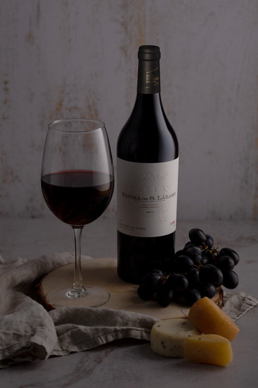 Red Wine: Vinha de São Lázaro — Single Vineyard (2021), a glass of wine, black grapes, and assorted cheeses.